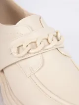 Mocasines negros de símil cuero con aplique metálico tipo cadena en la parte superior, ajuste con velcro y plataforma de 5cm.