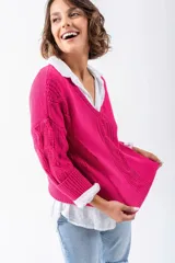 Sweater fucsia de tejido de punto con escote en V y mangas largas con detalle de trenzas. Corte holgado.