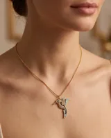 Collar de bronce dorado con cadena fina y dije en forma de colibrí esmaltado en tonos celestes y negros, con incrustaciones de circonias y un ojo turco en el centro.
