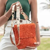 Bandolera de cuero vacuno color naranja, con correa larga ajustable y removible. Interior forrado con bolsillo para el móvil.