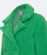Campera alargada de sherpa color verde manzana, con cuello solapa, cierre cruzado con botones y bolsillos delanteros.