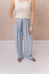 Pantalón amarillo de corte amplio y pierna recta, confeccionado en tela liviana con caída fluida. Cuenta con cintura elastizada, cordón regulable en contraste y bolsillos laterales.