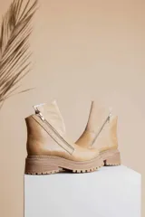 Botas cortas de cuero color beige, con cierre lateral y suela track.