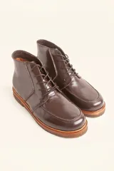 Bota acordonada de cuero vacuno con acabado charol color suela, con suela de goma tipo crepe y costuras reforzadas.