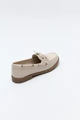 Zapato náutico de cuero sintético color marrón, con cordones decorativos, costuras a la vista y suela de goma antideslizante.