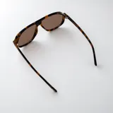 Lentes de sol Tyla de estilo aviador con armazón negro de policarbonato y detalles metálicos dorados en las bisagras. Cuentan con lentes oscuras con protección UV400.