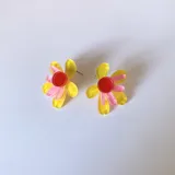 Aros tipo botón con forma de flor de pétalos turquesa y centro rosa y naranja.
