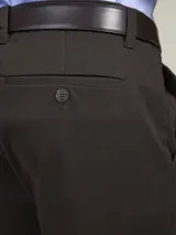 Pantalón de vestir azul marino, de corte recto, con bolsillos laterales y traseros. Se ajusta a la cintura con cinturón de cuero marrón.