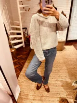 Sweater tejido en boucle color gris, de corte holgado y cuello con capucha.