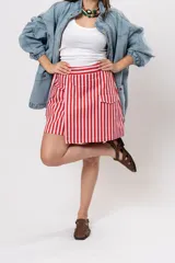 Pollera short cruzada con diseño a rayas verticales rojas y blancas, cintura elástica y bolsillos laterales cargo.