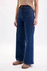 Pantalón jean ancho y elastizado en color azul oscuro, con bolsillos frontales aplicados y costuras pespuntadas en contraste.