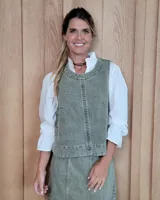 Chaleco de corte recto y largo a la cintura, confeccionado en denim con estampado de rayas verticales en tonos azul y blanco. Presenta cuello redondo y costuras visibles que definen su estructura.