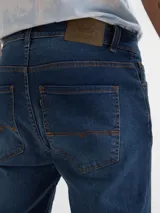 Pantalón de jean azul con roturas en las rodillas, corte skinny y tiro medio.