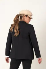 Blazer color camel de corte entallado, con doble botonadura dorada y solapas de muesca.