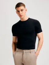 Camiseta de corte slim, color negro, con cuello redondo y mangas cortas.