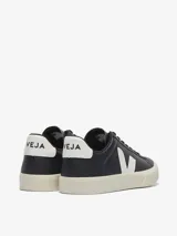 Zapatillas Veja modelo Campo, confeccionadas en cuero bovino negro con detalles en blanco en el talón y el logo lateral. Presentan suela de caucho amazónico en tono crema y cierre de cordones.
