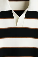 Sweater de punto suave con diseño a rayas horizontales en blanco, negro y marrón, cuello polo con abertura en V y manga larga con puños acanalados.