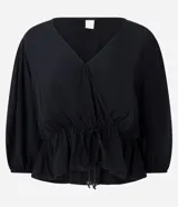 Blusa color vino tinto, con escote cruzado en V, mangas tres cuartos abullonadas con elástico en el puño y peplum ajustado en la cintura con lazo regulable.