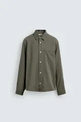 Camisa de corte relajado confeccionada en tejido fluido con mezcla de lyocell y algodón. Presenta cuello solapa, manga larga con puño abotonado, bolsillo de plastrón en el pecho y cierre frontal con botones. Posee un acabado con efecto lavado.