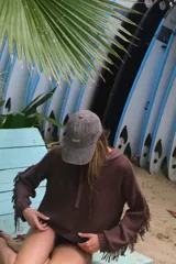 Buzo con capucha de tejido de punto abierto, color blanco roto, de corte oversize y manga larga con detalle de flecos en los puños.