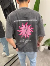 Remera gris con efecto lavado, corte holgado y estampa en la espalda con un sol con rostros y texto en blanco y rosa.