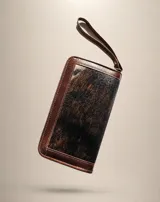 Billetera larga de cuero marrón y centro de pelo sintético con patrón animal print, con cierre perimetral y correa de muñeca incorporada.
