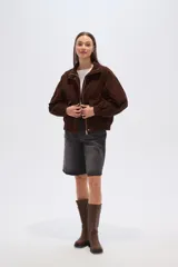 Campera corta marrón de pana, con cuello alto, cierre frontal con broches a presión, bolsillos plaqué con solapa y puños elásticos.