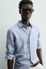 Camisa de hombre de manga larga, cuello italiano y corte regular fit, confeccionada en tejido de lino a rayas verticales azules y blancas.