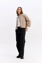 Saco de punto con textura tipo bouclé, de calce relajado y diseño levemente cropped. Cuenta con cuello redondo y cierre frontal mediante botones.