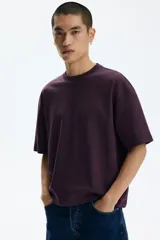 Remera boxy de algodón en punto liviano color bordó, de hombros caídos, cuello redondo ribeteado acanalado y corte oversized.
