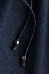 Short de denim liviano, color azul, de tiro alto con cintura elástica fruncida y cordón ajustable con terminales metálicas. Corte holgado.