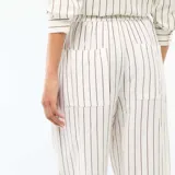 Pantalón palazzo de lino mezclado, color blanco con diseño de rayas verticales finas en color negro, de corte ancho y tiro alto con cintura elástica.
