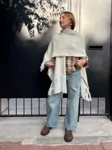 Camisa de corte holgado con estampado de cuadros escoceses en tonos beige y marrón. Presenta cuello clásico, cierre frontal con botones y mangas largas.