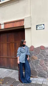 Camisa de corte oversize con estampado de cuadros en tonos grises. Presenta cuello camisero, mangas largas abullonadas y cierre frontal con botones.