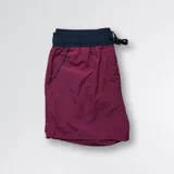 Short de baño color bordó con cintura elástica negra y cordón de ajuste. Cuenta con malla interior y bolsillo trasero con cierre.