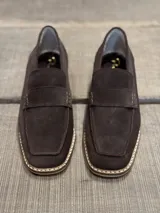 Mocasines de gamuza color marrón chocolate, con detalle de costuras en contraste en la suela.