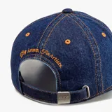Gorro tipo gorra de Nude Project, confeccionado en denim azul con costuras y bordado frontal en color naranja.