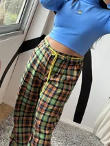 Pantalón sastrero con estampado escocés en tonos verde, naranja y azul marino.
