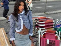 Camisa crop de manga larga con estampado de cuadros en tonos azules y amarillos. Presenta un diseño con volados de encaje blanco en la parte frontal y en el ruedo, con cierre de botones.