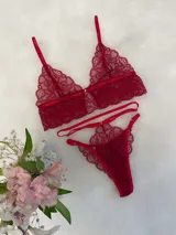 Conjunto de lencería compuesto por un bralette de encaje con cierre frontal de gancho y una tanga de encaje con tiras laterales regulables.