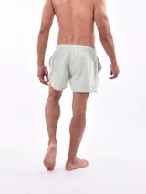 Short de baño blanco con estampado de hojas en tonos azules y rosados, cintura elástica con cordón ajustable.