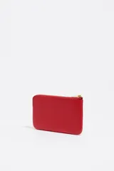 Monedero pequeño de piel vacuna color rojo, con textura granulada, cierre de cremallera dorado y logo metálico de Bimba y Lola en dorado.