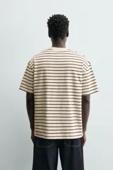 Camiseta color arena de algodón compacto, corte recto, cuello redondo y mangas cortas.