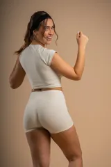 Short deportivo color crema, de tiro alto y calce ajustado.