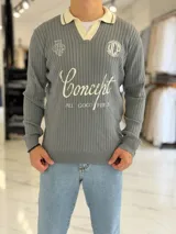 Sweater de punto gris con cuello polo y solapa en color beige. Presenta bordados y estampas tipográficas en el frente con la inscripción "Concept" y detalles circulares.