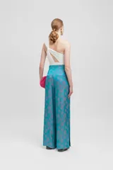 Pantalón palazzo de tiro alto con estampado floral en tonos celeste y gris. Presenta cinturilla plisada y aberturas laterales.