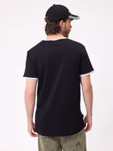 Remera de corte regular fit, color azul marino con cuello y bordes de mangas en color blanco. Presenta el logo de la marca Rusty estampado en el centro del pecho.