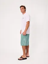 Remera negra de ajuste holgado con gran estampado gráfico en la espalda de temática tropical con una playa, palmeras y la inscripción "Welcome to Surfers Paradise".