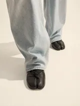 Ballerinas de cuero vacuno con diseño de puntera dividida, estilo tabi, con detalle de lazo frontal.