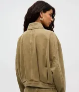 Campera bomber de jean color verde oliva, de corte holgado y diseño corto. Cuenta con cuello polo, mangas largas y cierre frontal con botones.